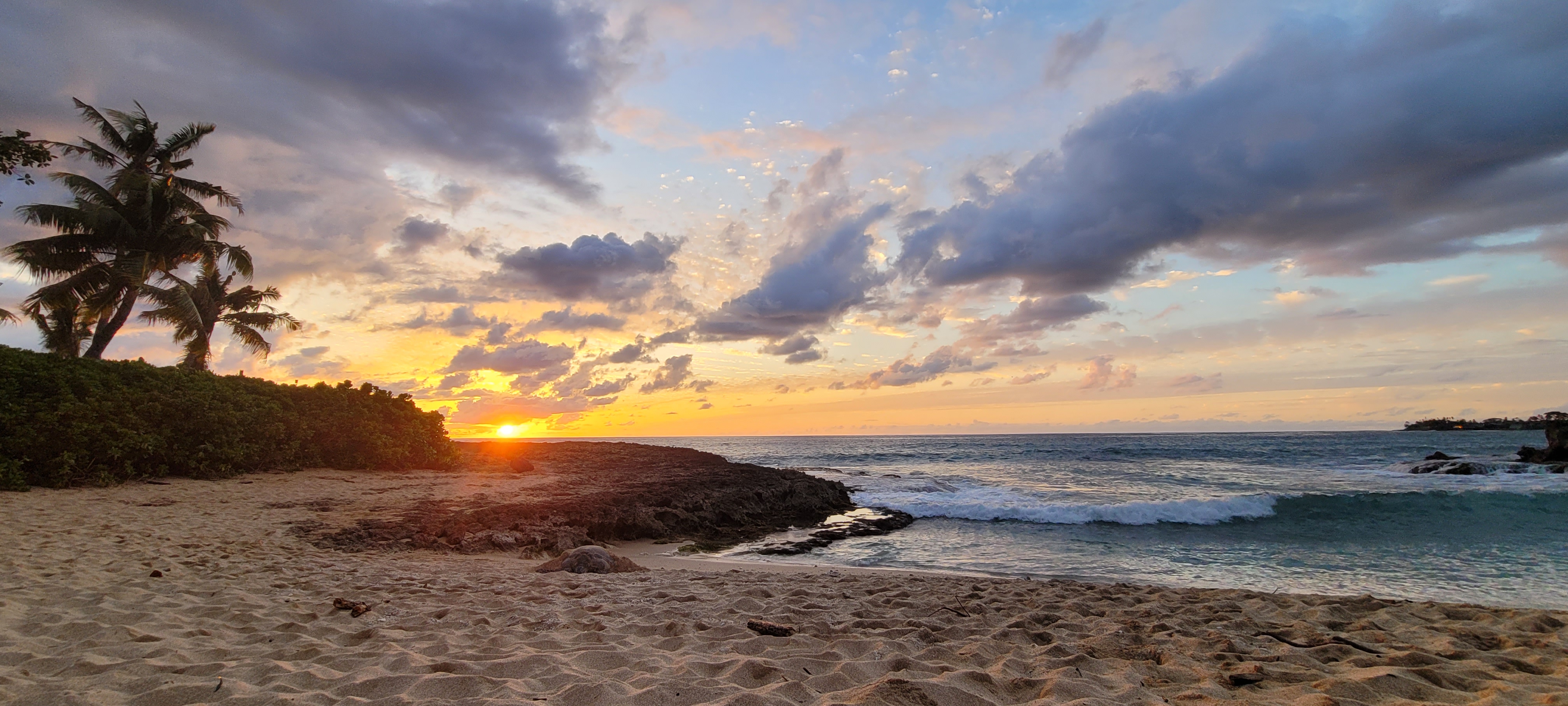 A coral shelf above the waves at sunset