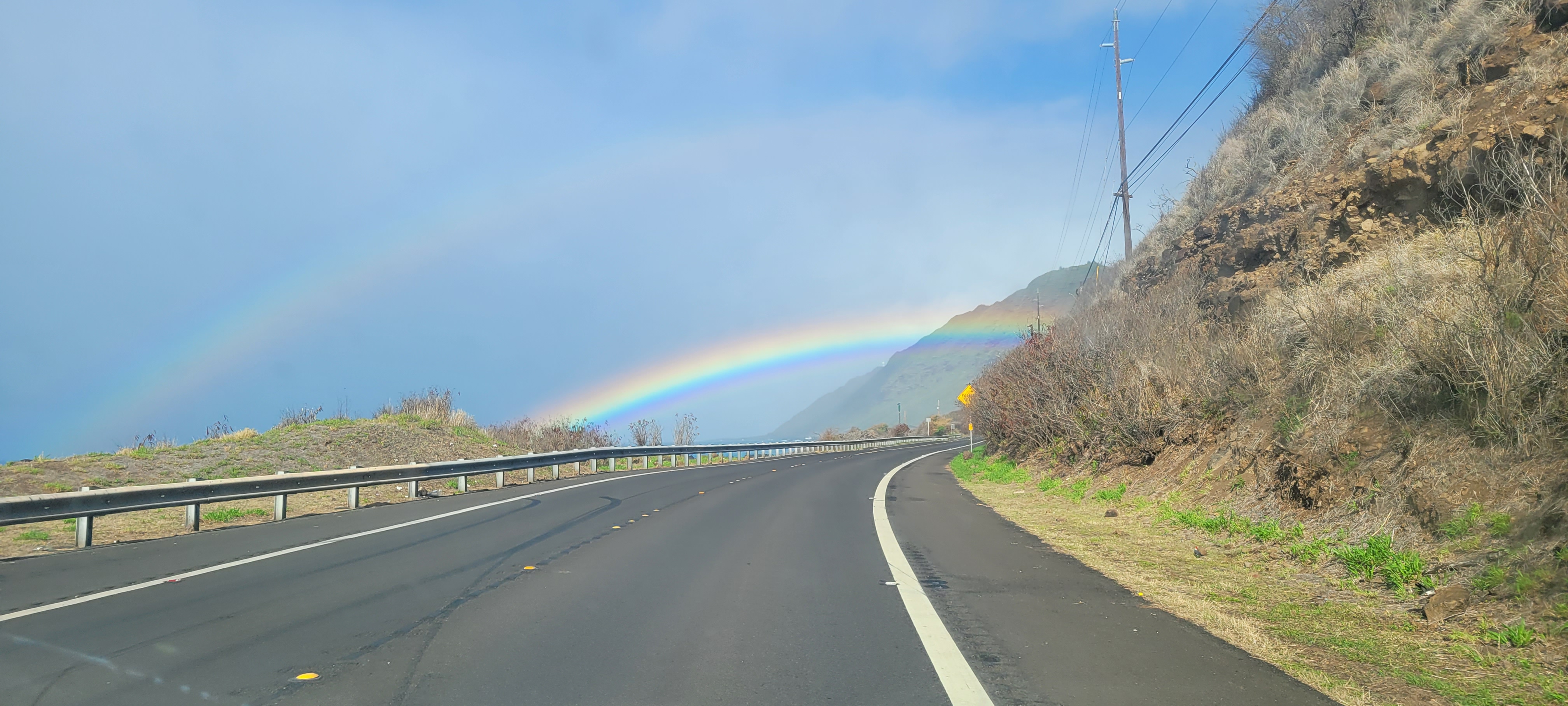 A rainbow over a highway.