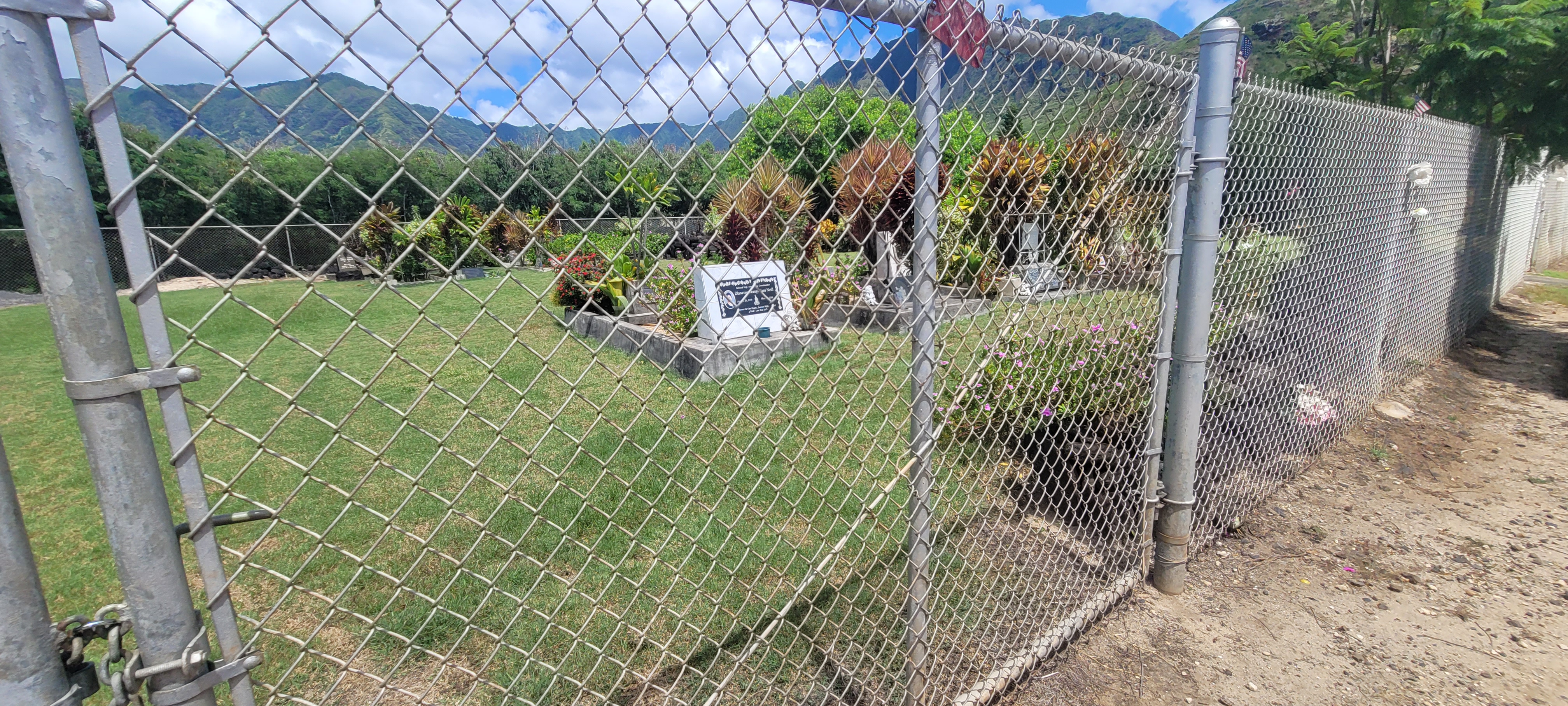 A cemetary behind a chain link fence.