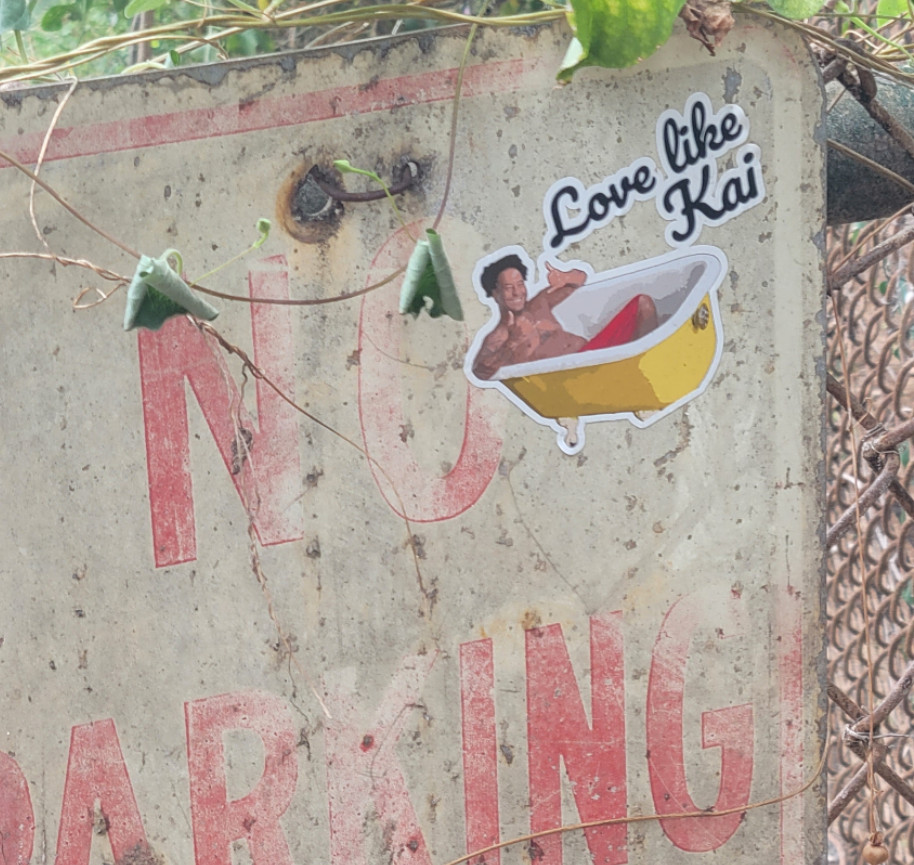 A weathered sign with a sticker of a man in a bathtub.